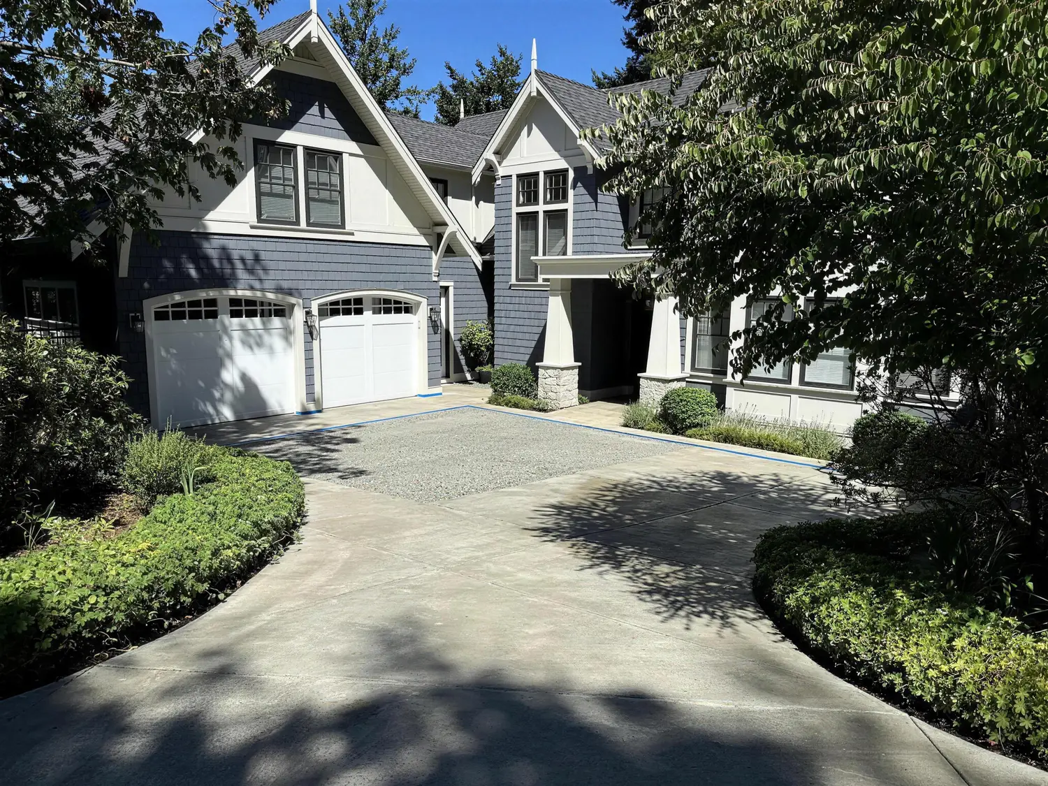Twin-garage craftsman home with freshly sealed concrete driveway